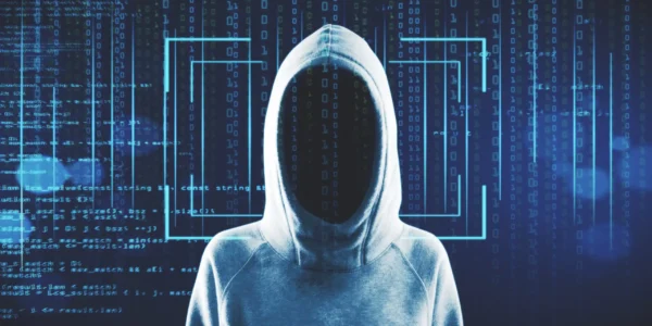 A shadowed, hooded figure with a featureless face standing against a blue digital background of binary code and cyber network connections.